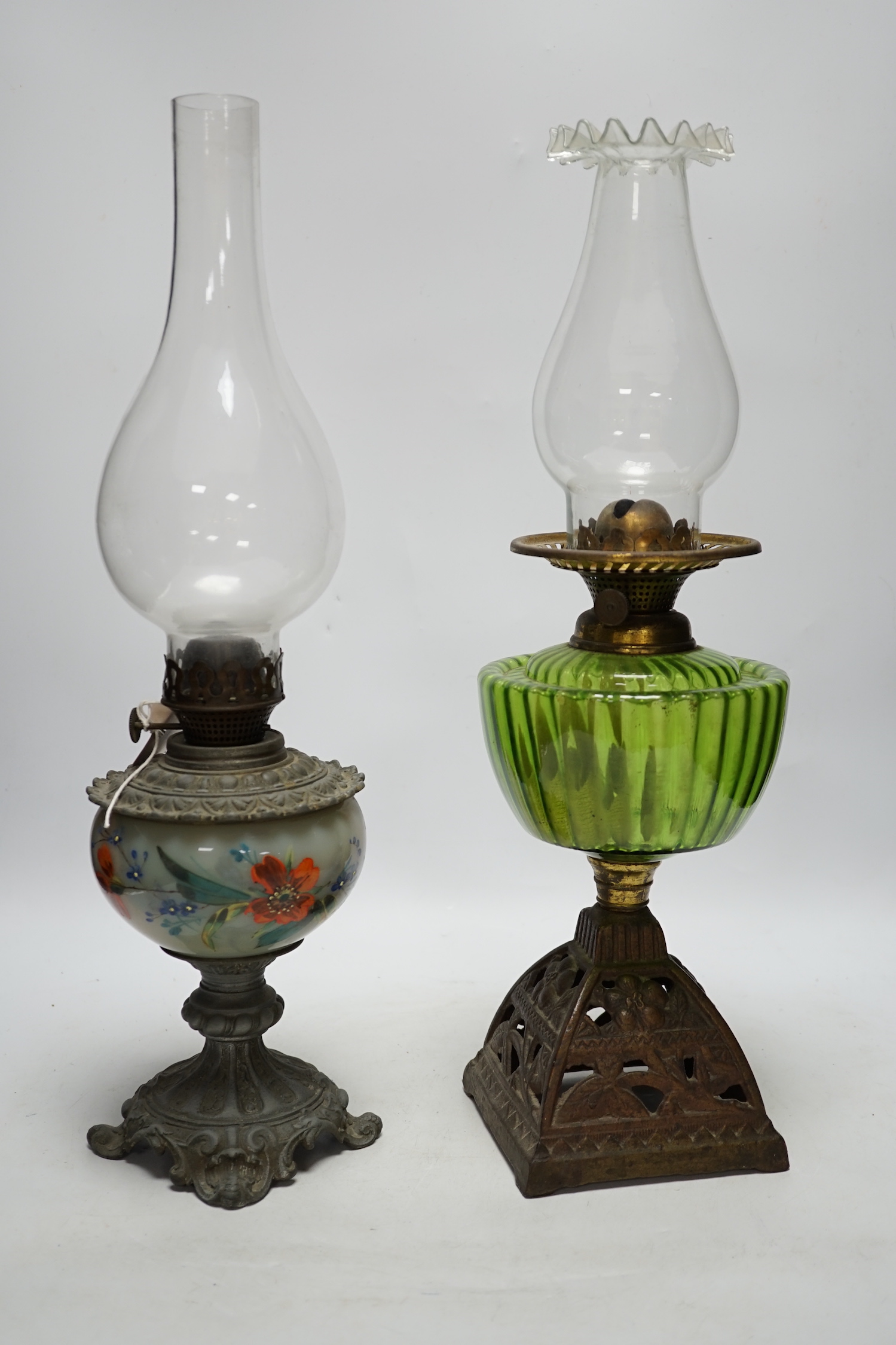 Two oil lamp bases with glass reservoirs, largest 48cm high
